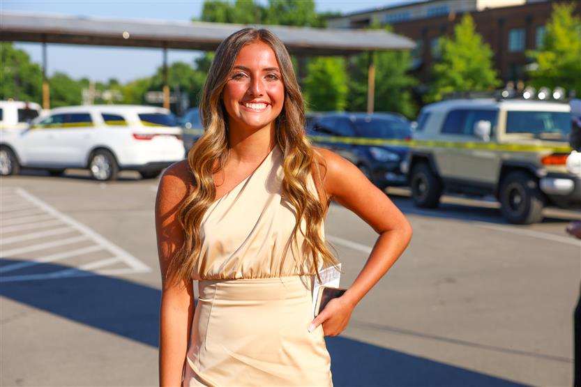 A young woman wearing a yellow dress smiles
